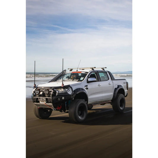 Modified white pickup truck with Rockarmor GT Steel Hoop Bullbar, driving lights, and fog lights