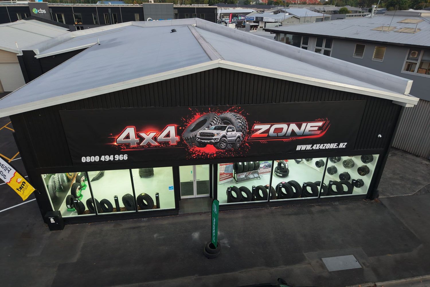 Aerial view of a building with '4x4 Zone' branding and display of products and 4WD wheels and accessories