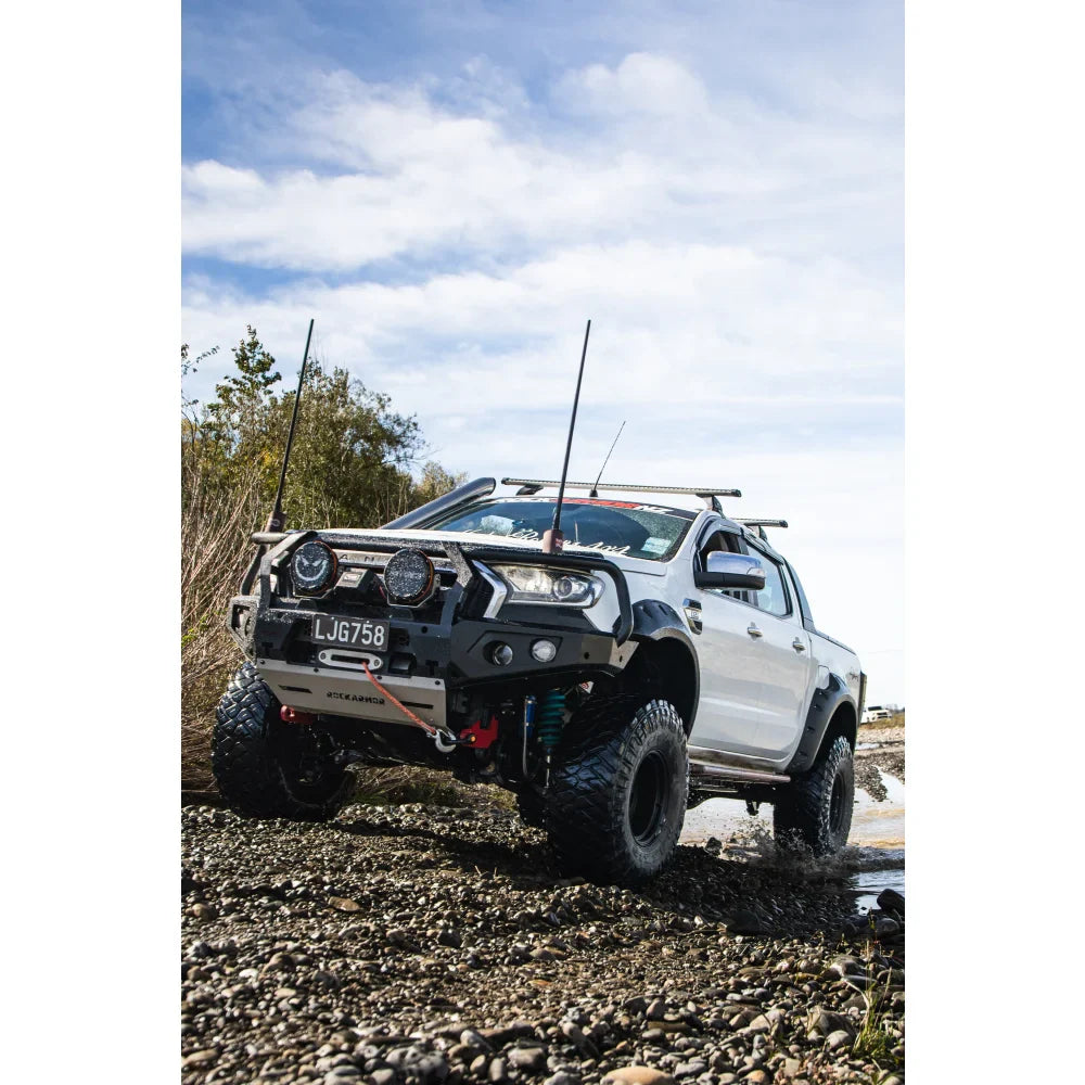 White off-road pickup truck with hoop bullbar, driving lights, and synthetic winch rope