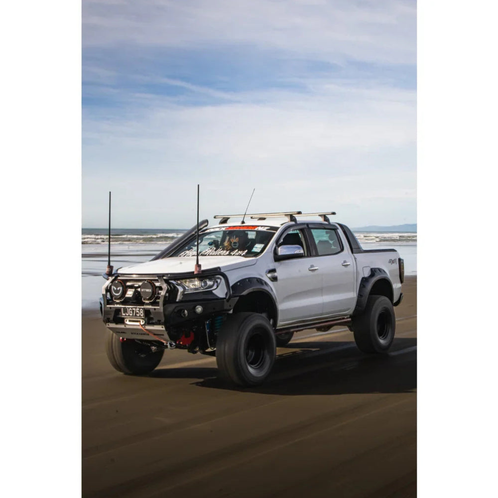 Modified white pickup truck with Rockarmor GT Steel Hoop Bullbar, driving lights, and fog lights