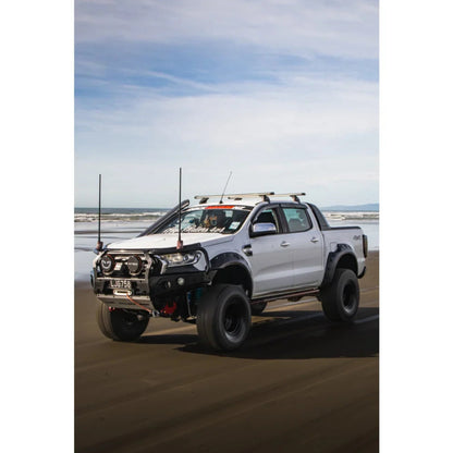 Modified white pickup truck with Rockarmor GT Steel Hoop Bullbar, driving lights, and fog lights