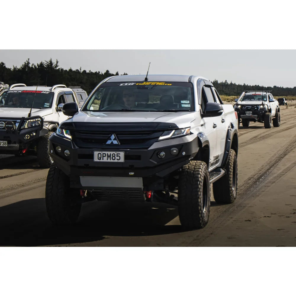 Modified white pickup truck with bull bar, driving lights, and synthetic winch rope