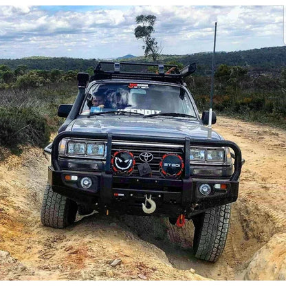 Black off-road Toyota Land Cruiser with steel bullbar and fog lights for enhanced protection